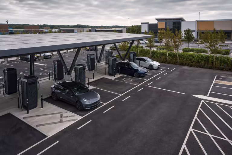 Rapid electric vehicle charging bays beneath a solar canopy in a commercial car park