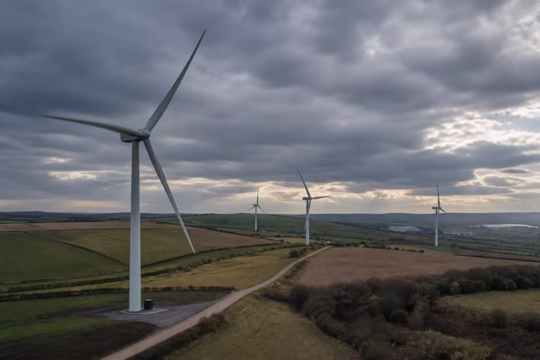 Modern onshore wind turbines across managed UK farmland